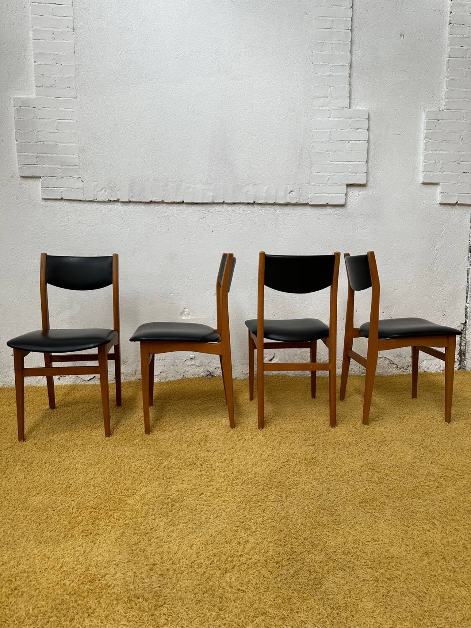4 Scandinavian chairs in teak and black faux leather.