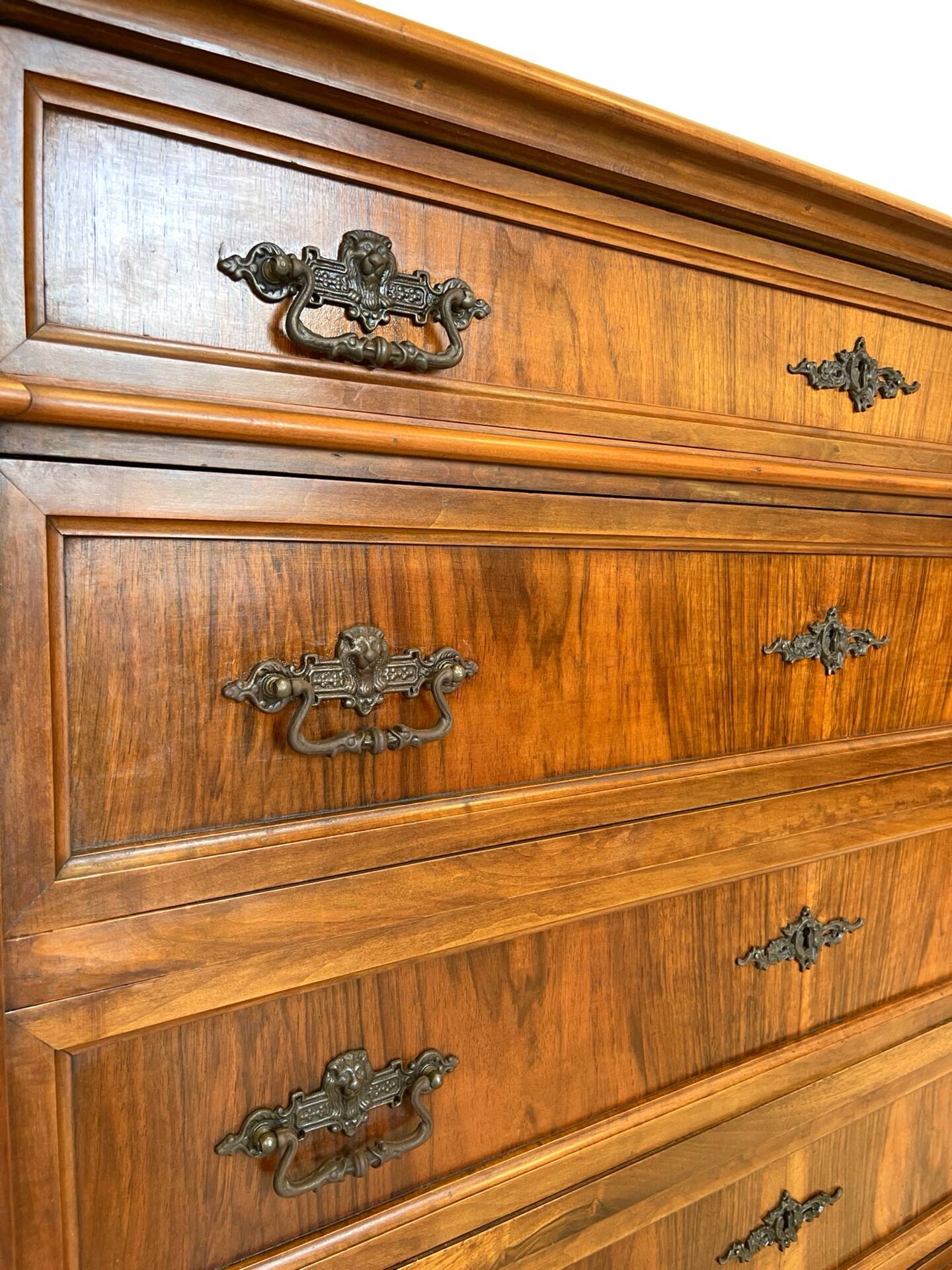 Antique walnut commode with bronze handles in the shape of a lion's mask,