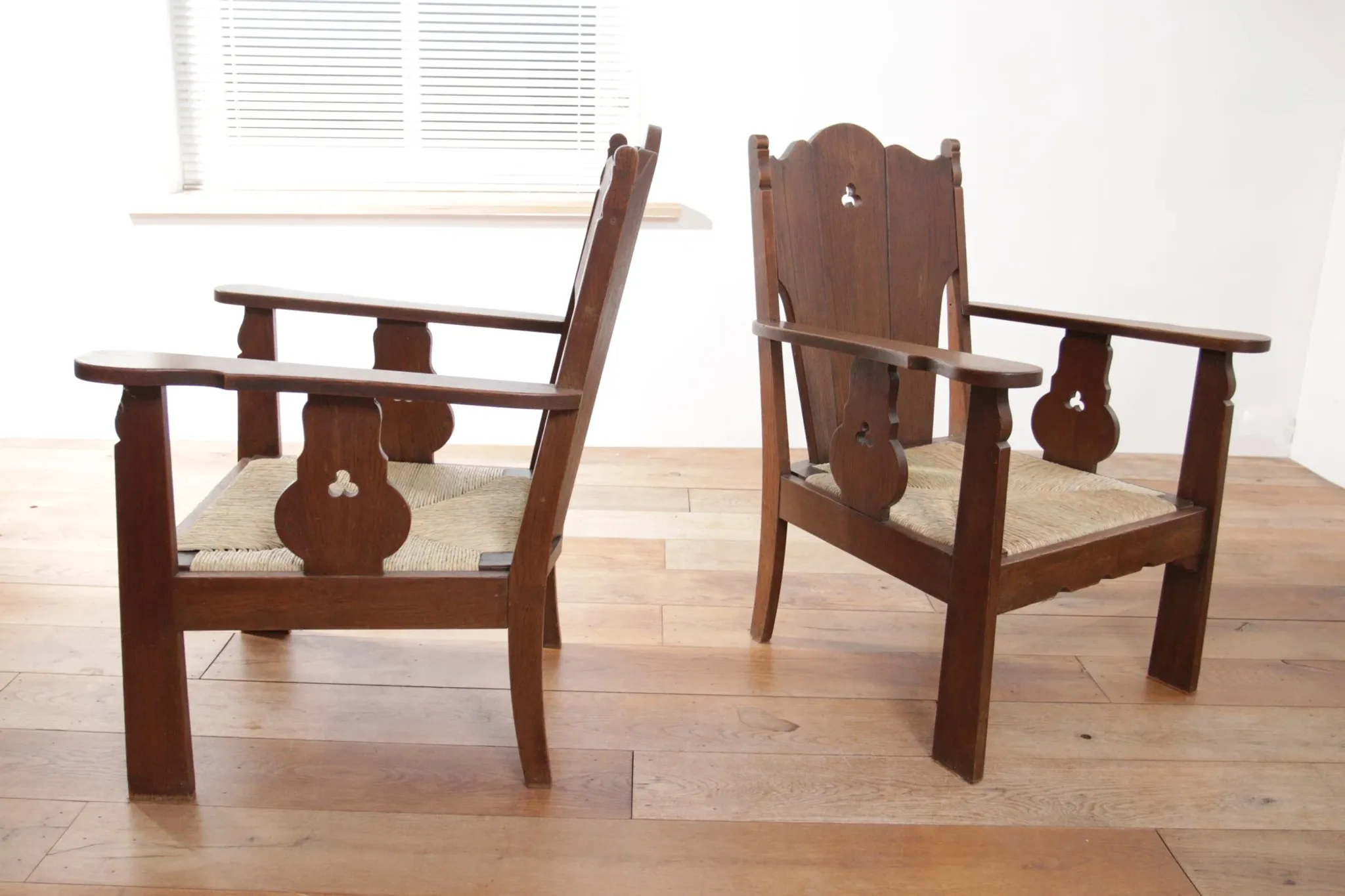 Pair of low Brutalist oak lounge chairs with new rush seats – circa 1935