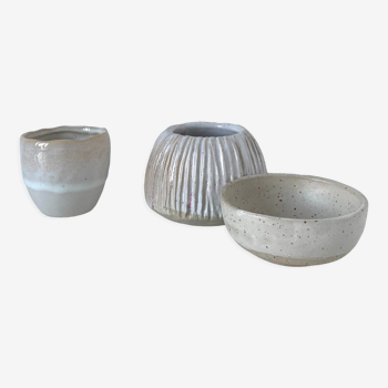 Meeting of three artist's ceramic objects including two pots and a cream covered bowl