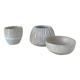 Meeting of three artist's ceramic objects including two pots and a cream covered bowl