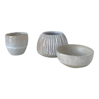 Meeting of three artist's ceramic objects including two pots and a cream covered bowl