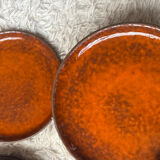 Orange glazed ceramic plates from the 1970s