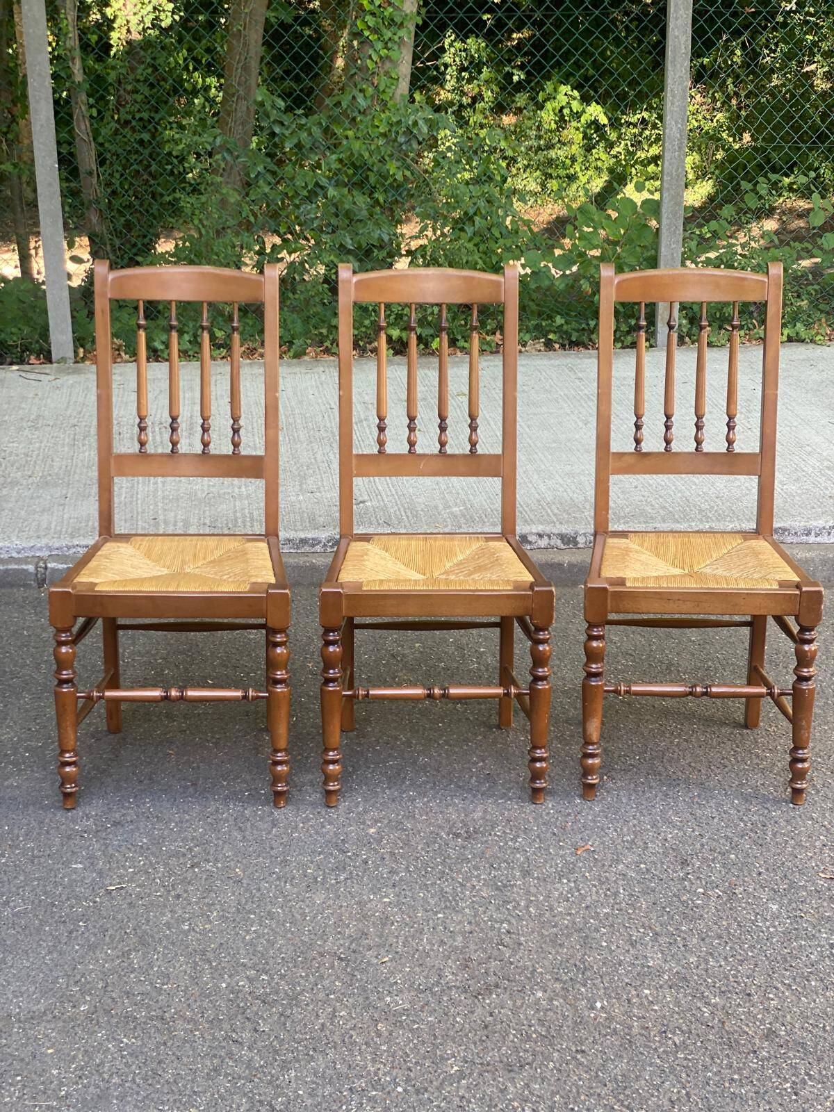 Solid wood chair with a straw seat and carved bar backrest.