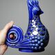 Pair of ceramic glazed candlesticks in the shape of roosters, signed A.G Roger, year 1948.