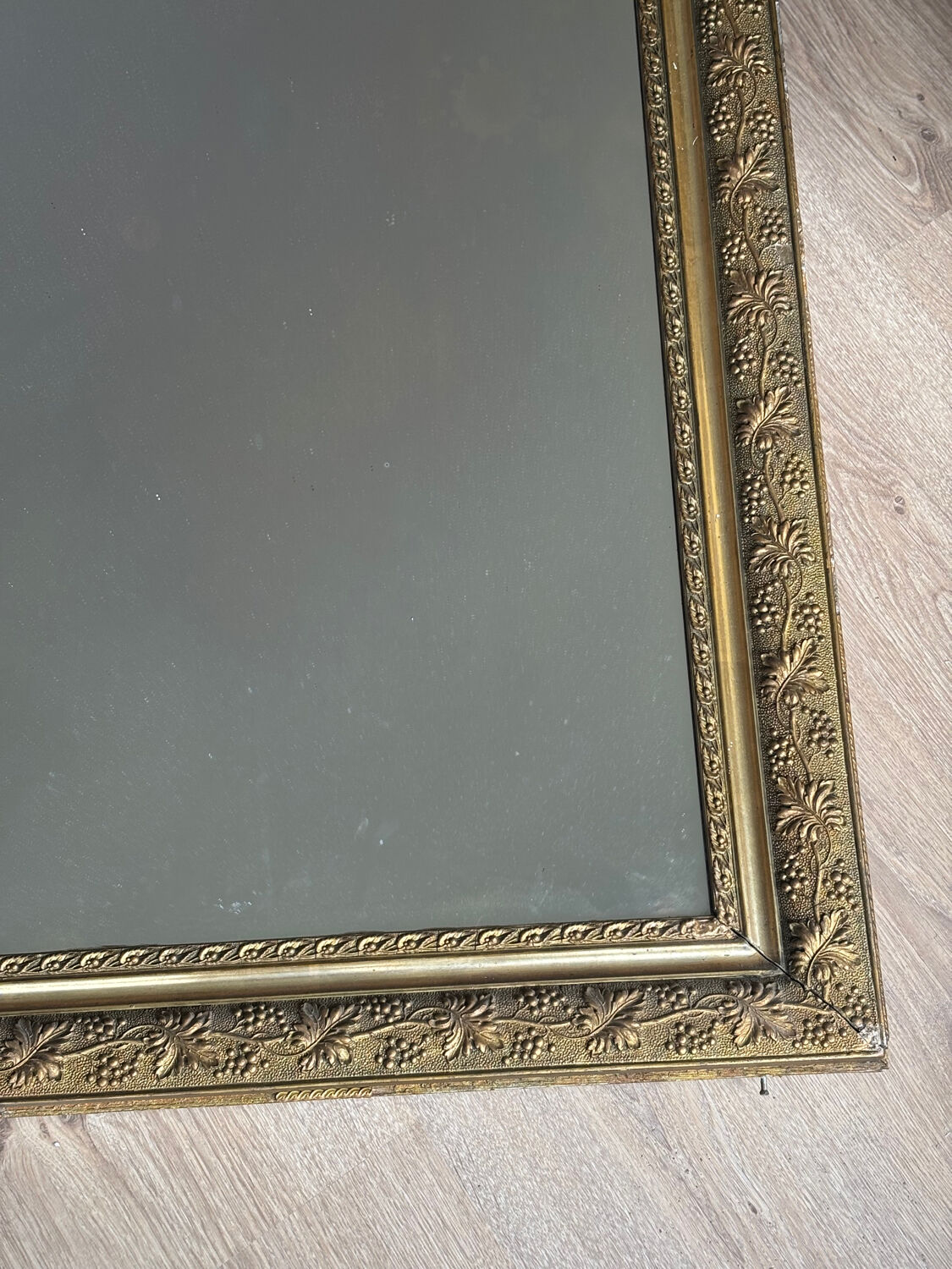 Golden mirror with a pediment from the early 20th century.