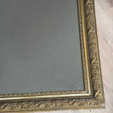 Golden mirror with a pediment from the early 20th century.