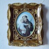 Old religious light frame in gilded stucco and curved glass