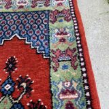 Vintage hand-knotted wool rug with polychrome decoration on a red, blue, green background 150 x 63 cm