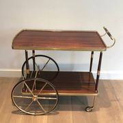 Mahogany and brass rolling table in the style of Maison Jansen.