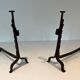 Pair of wrought iron andirons with adjustable supports and tripod feet.