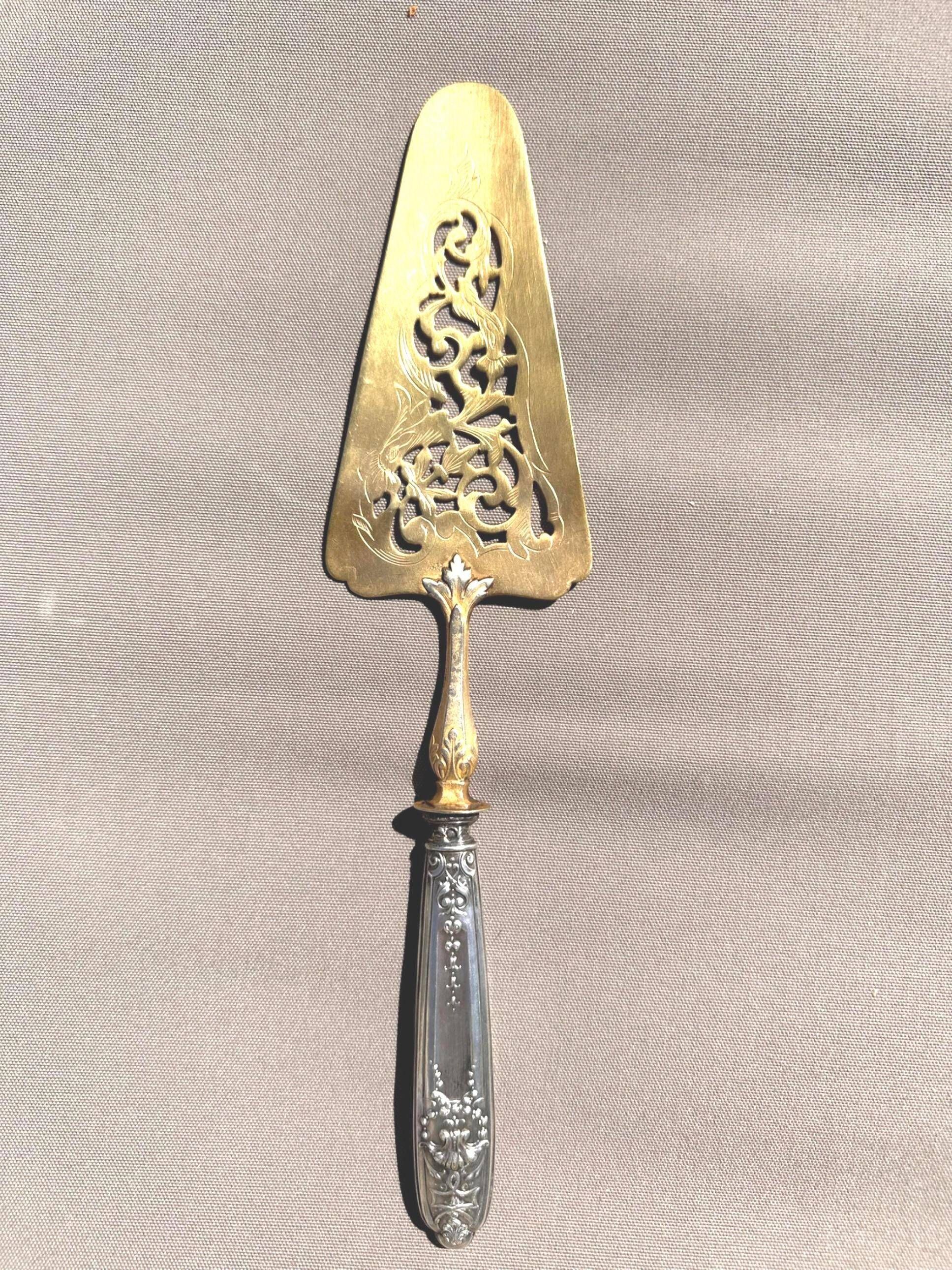 Silver cake server with gilded metal, pierced blade, 19th century.