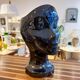 Black ceramic vase with a woman's face.