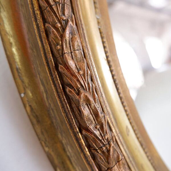 Wear consistent with age and use  Wood and gilded plaster ''Noeud d'Amour'' Oval mirror