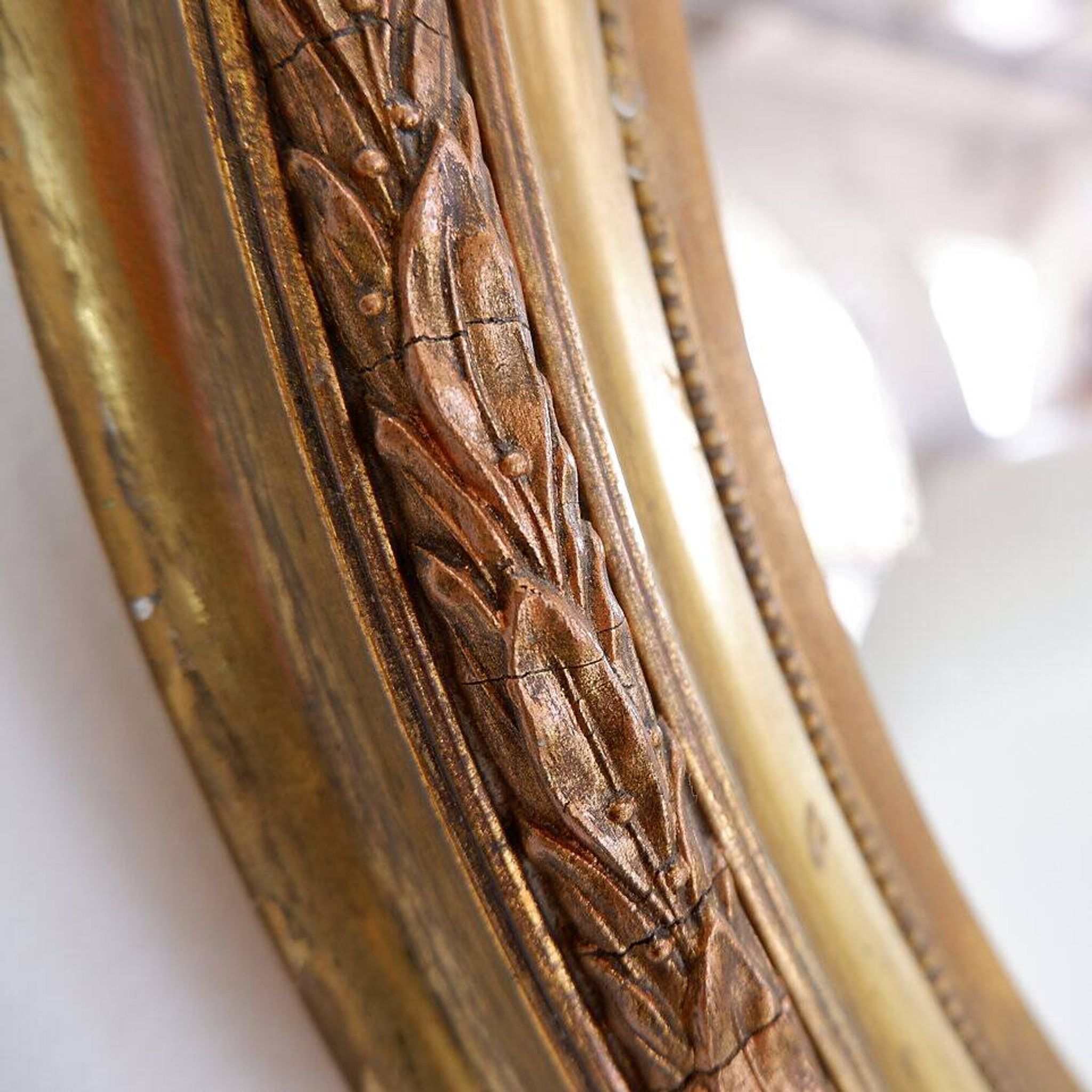 Wear consistent with age and use Wood and gilded plaster "Noeud d'Amour" Oval mirror