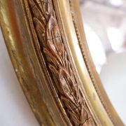 Wear consistent with age and use Wood and gilded plaster "Noeud d'Amour" Oval mirror