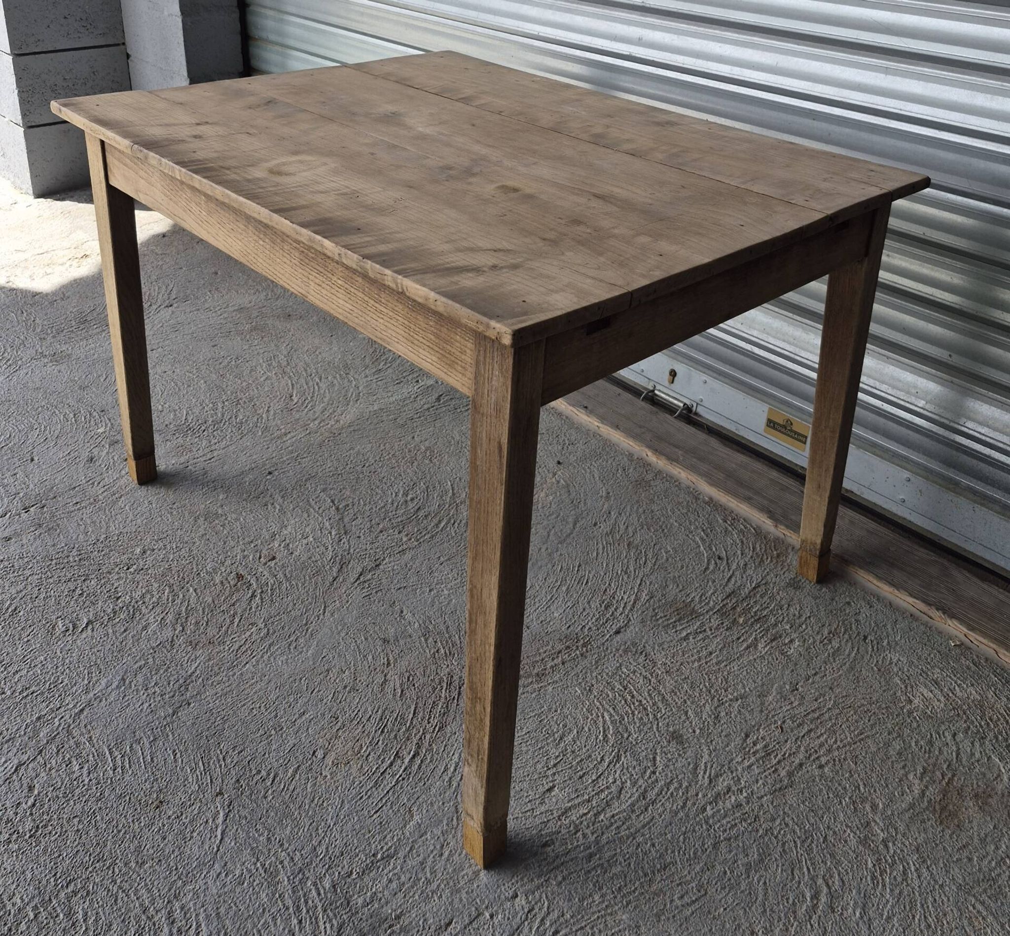 Old farmhouse table with its 2 extensions and raised legs.