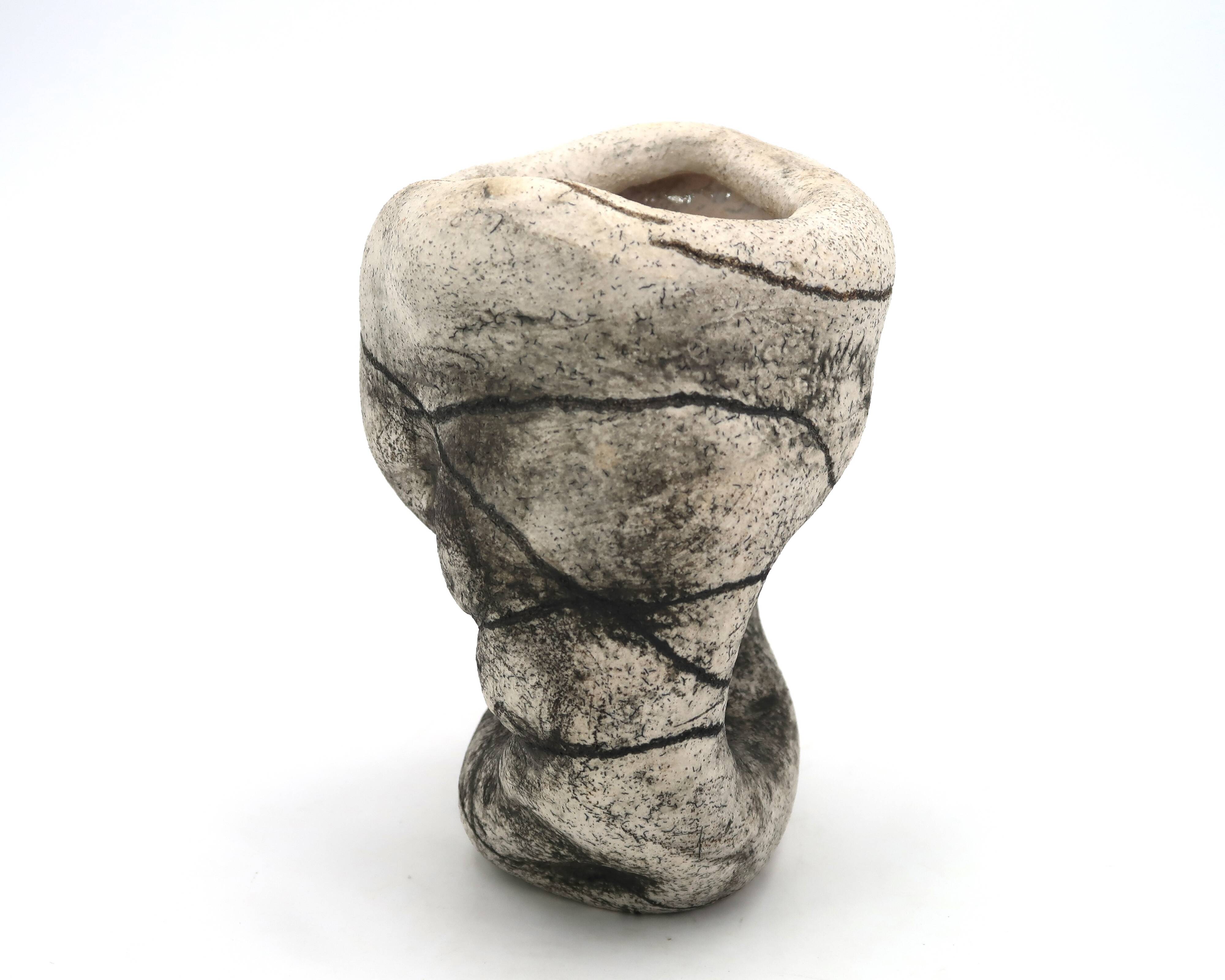 Ceramic vase sculpture decorated with faces and featuring a hole, 1980s.