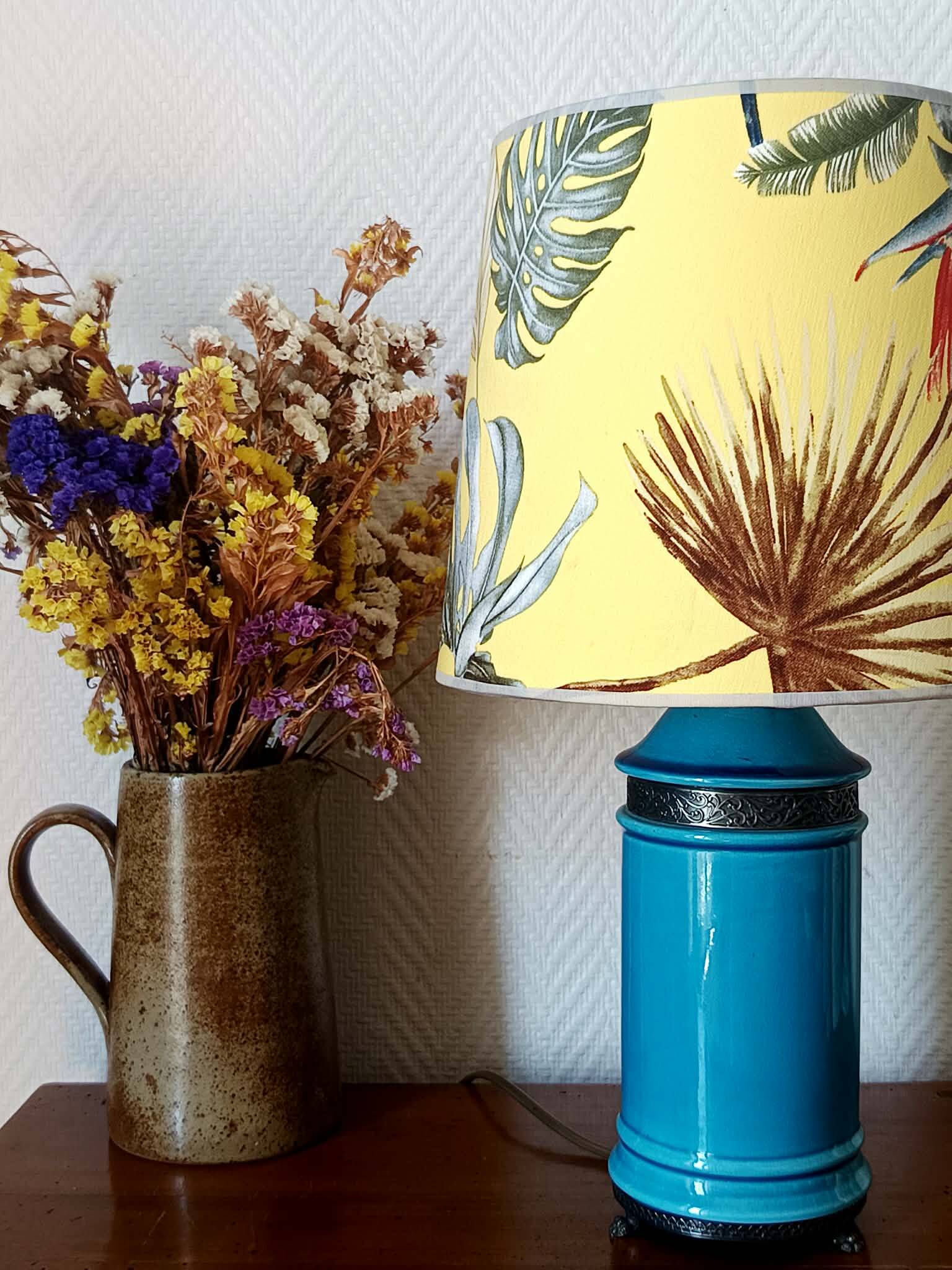 Blue ceramic lamp with claw feet and foliage lampshade.