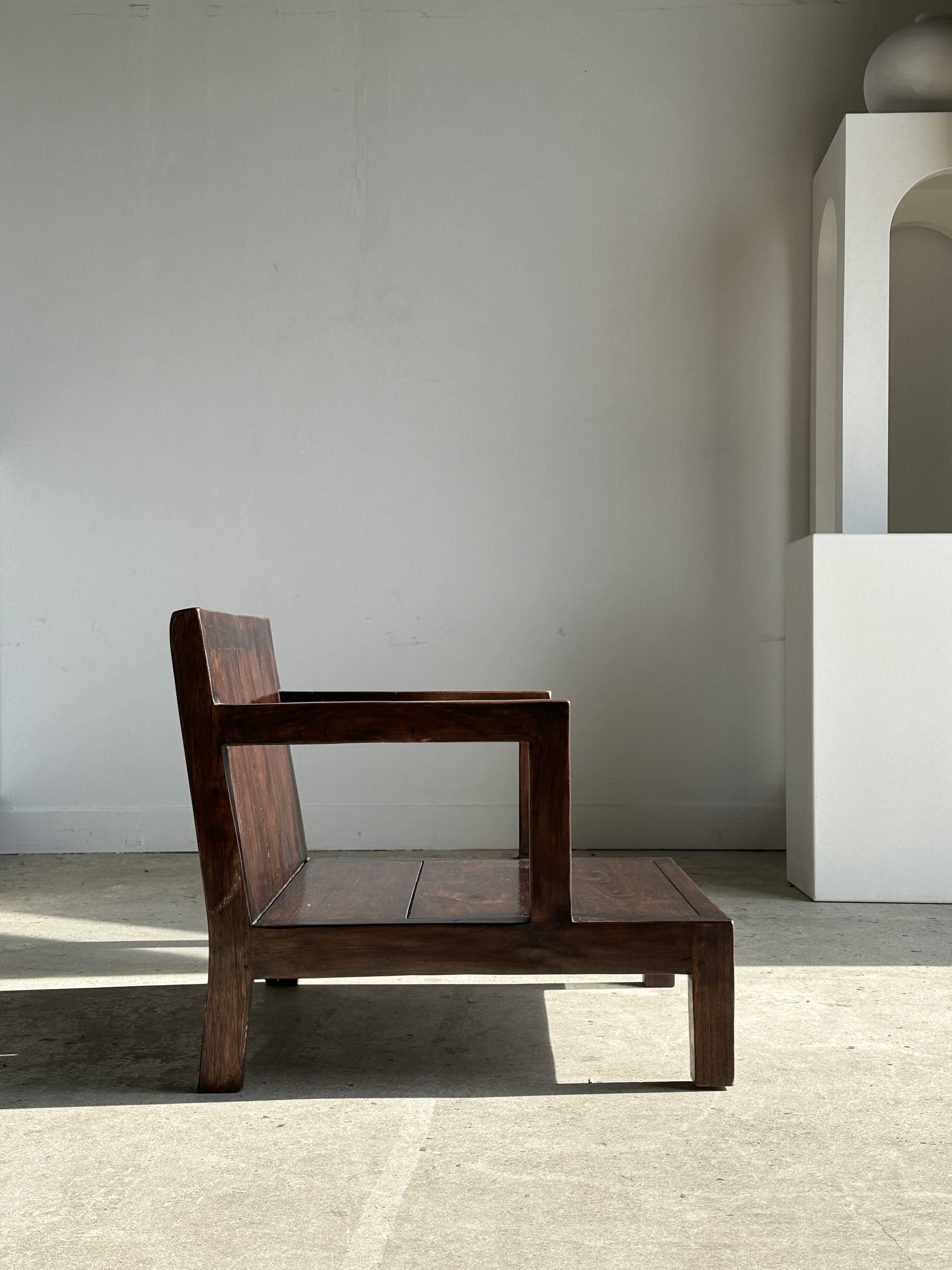 Small low armchair in varnished brown wood