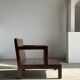 Small low armchair in varnished brown wood