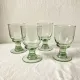 4 stemmed glasses made of handcrafted blown glass in green hue.