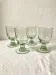 4 stemmed glasses made of handcrafted blown glass in green hue.