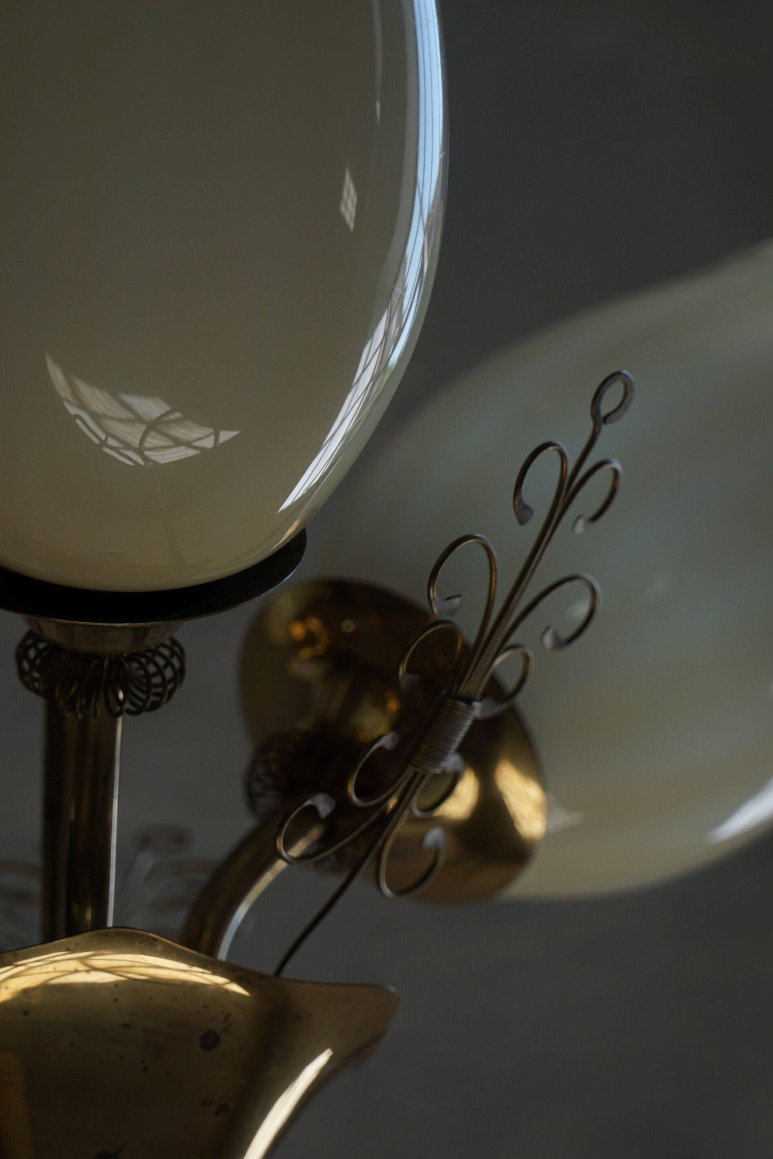 Paavo Tynell for Idman Oy, three-branch chandelier in brass and glass, mid-century, 1940s.