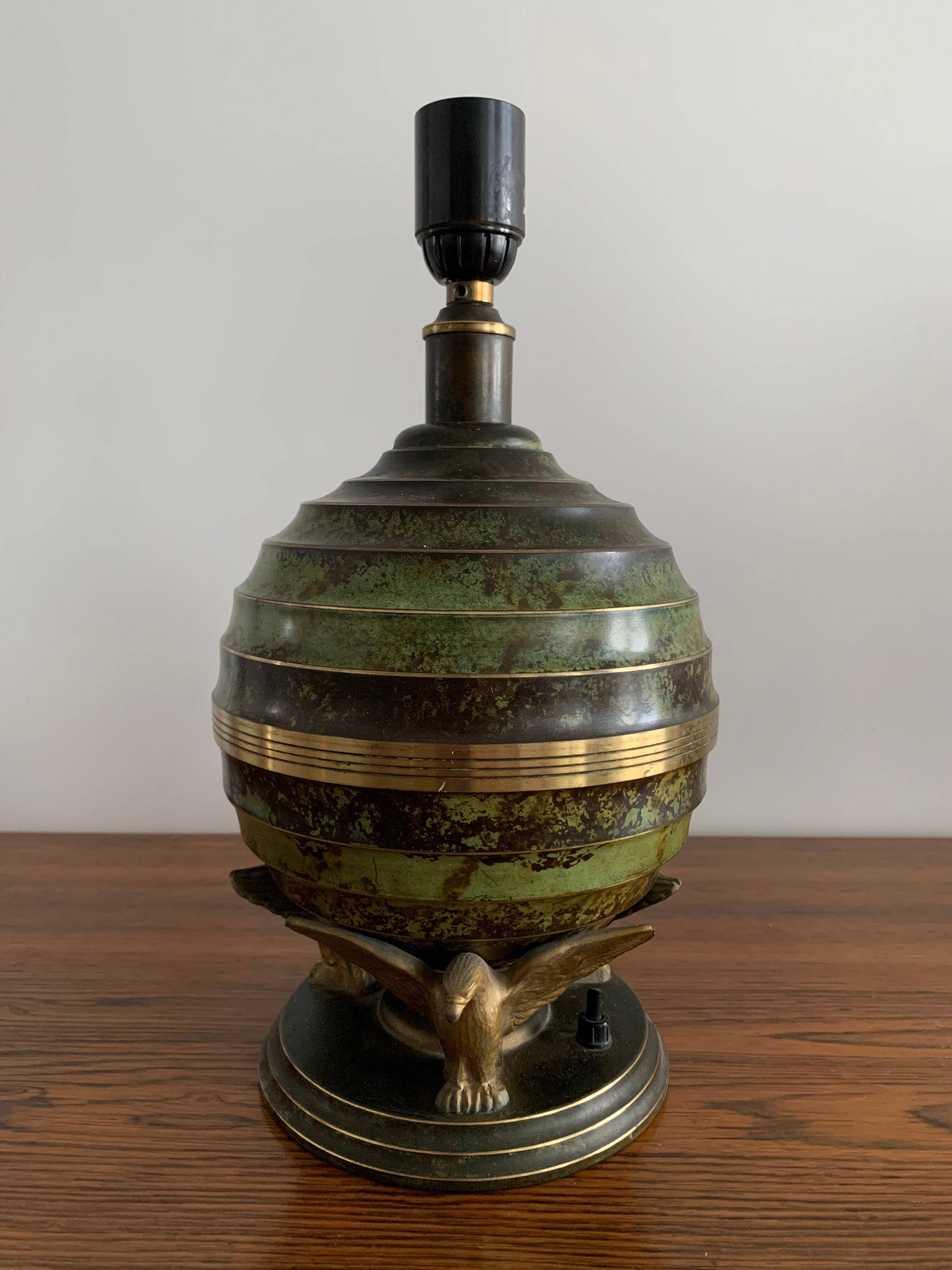 Art Deco table lamp in patinated bronze with eagles holding a globe, France 1940.