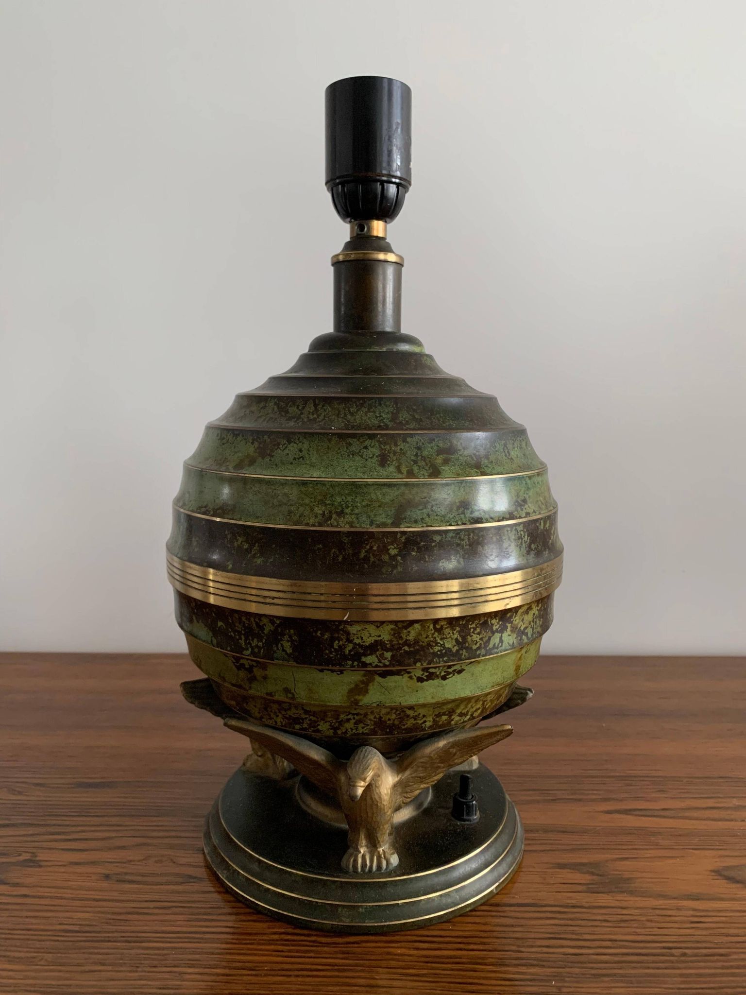 Art Deco table lamp in patinated bronze with eagles holding a globe, France 1940.