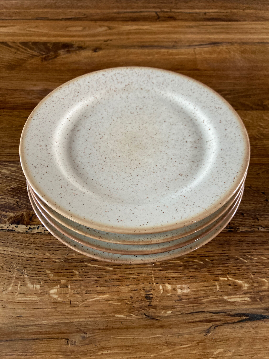 Four beige speckled plates