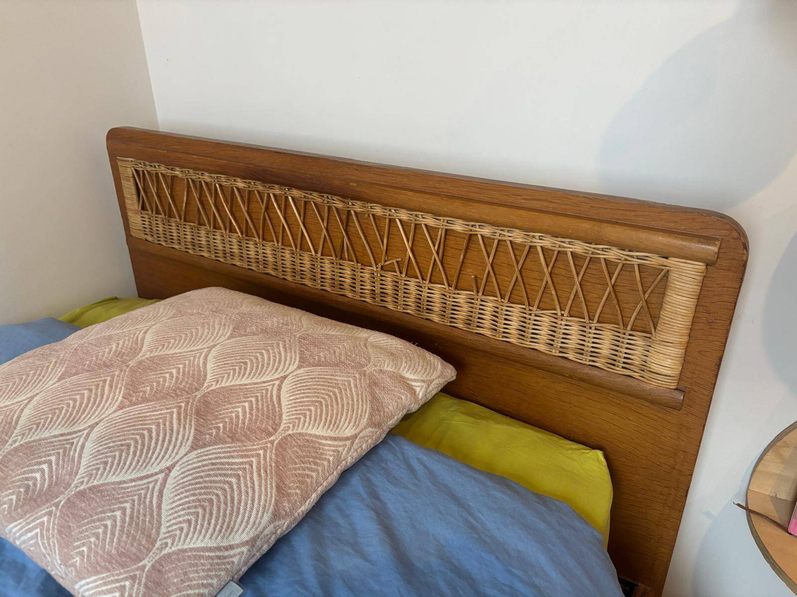Vintage single bed made of rattan from the 1970s with a mattress.