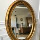 Grand miroir oval en stuc doré vintage
