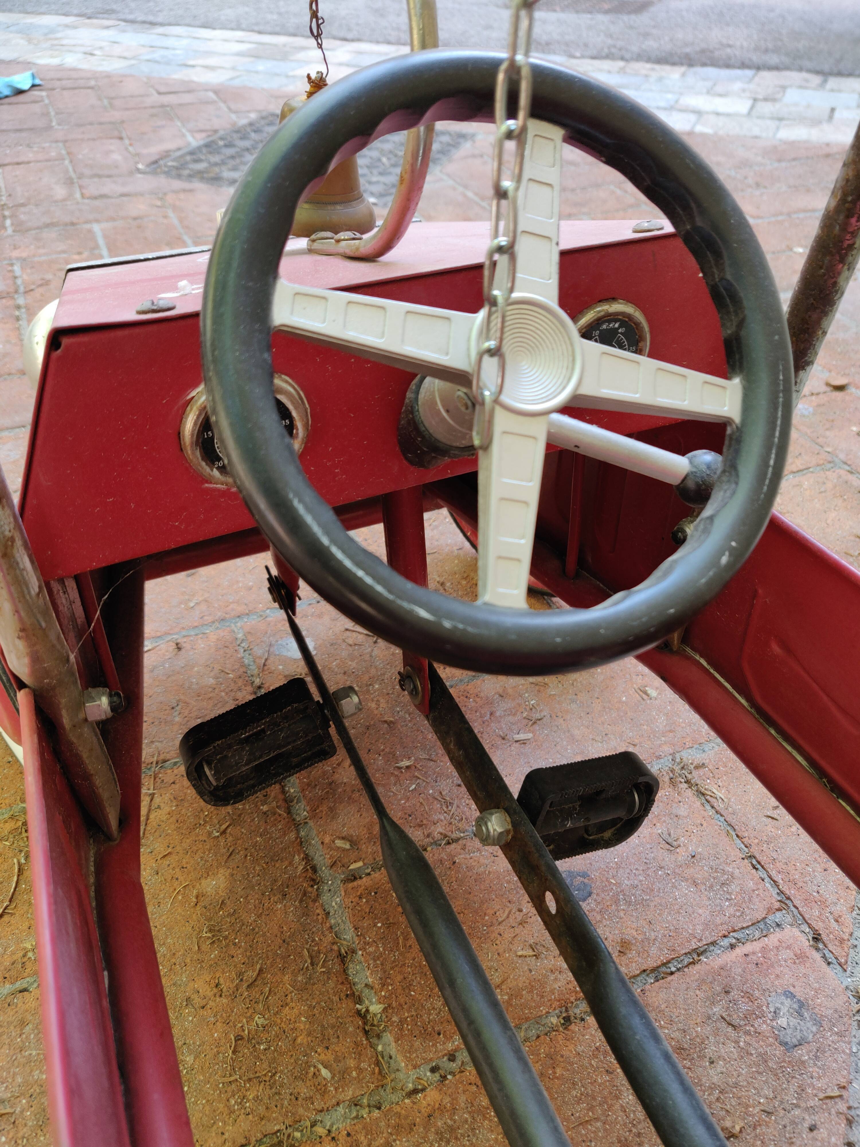 Old pedal car in tole fire truck