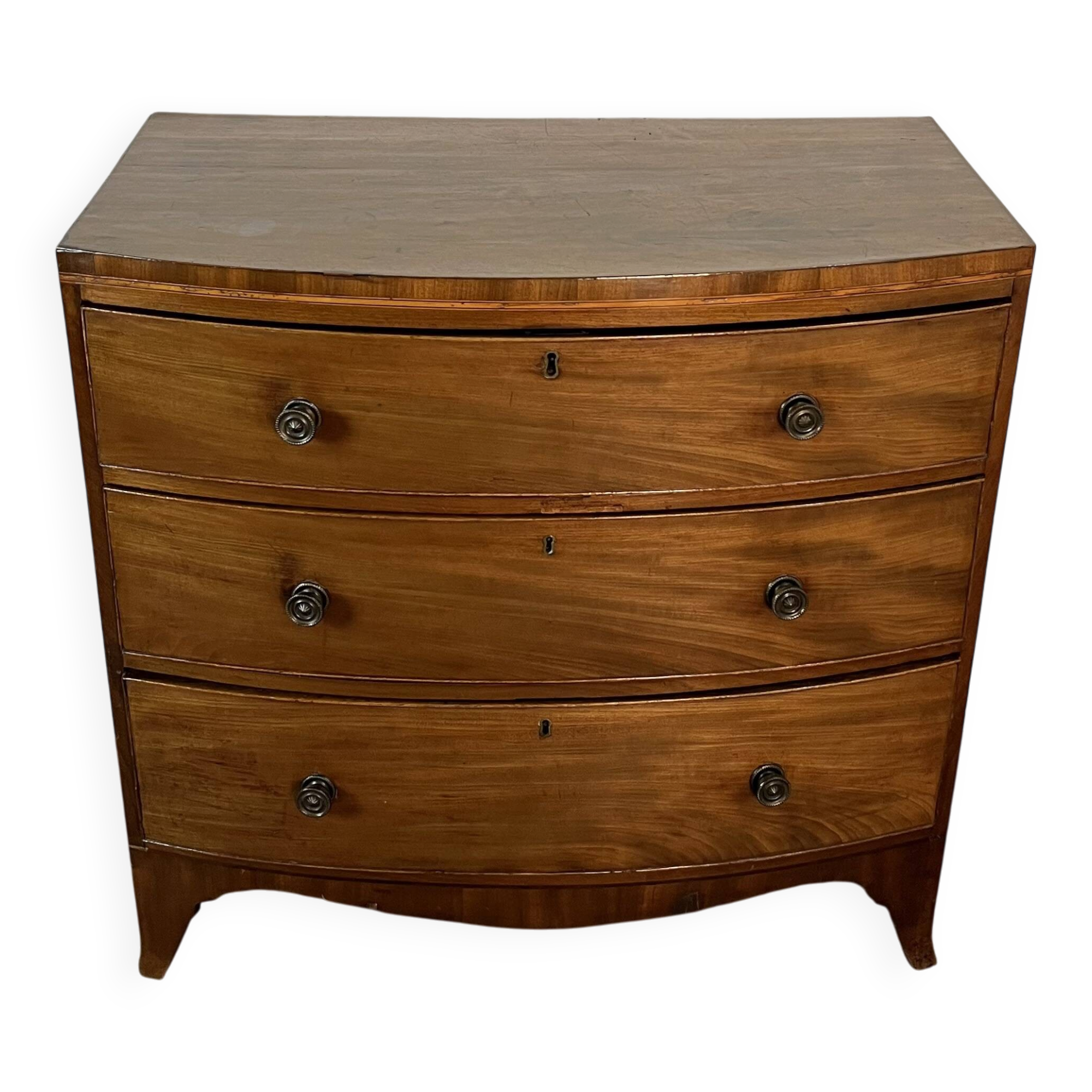 English commode from the George III Regency period, bombe shape in mahogany veneer.