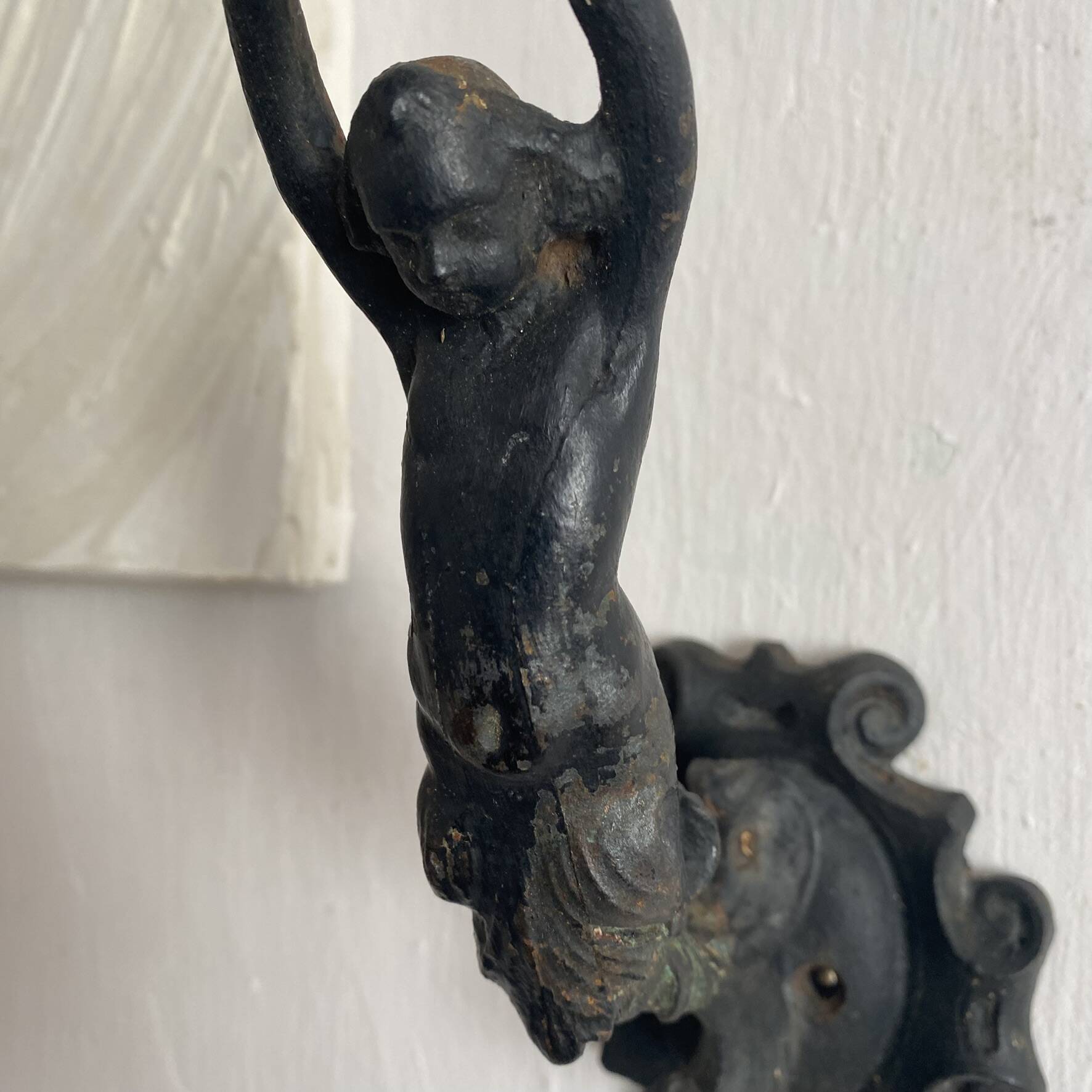 Antique cast iron coat hook with swimmer and shell basin.