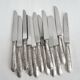 12 antique silver-plated knives with acanthus shell decoration and stainless steel blades.