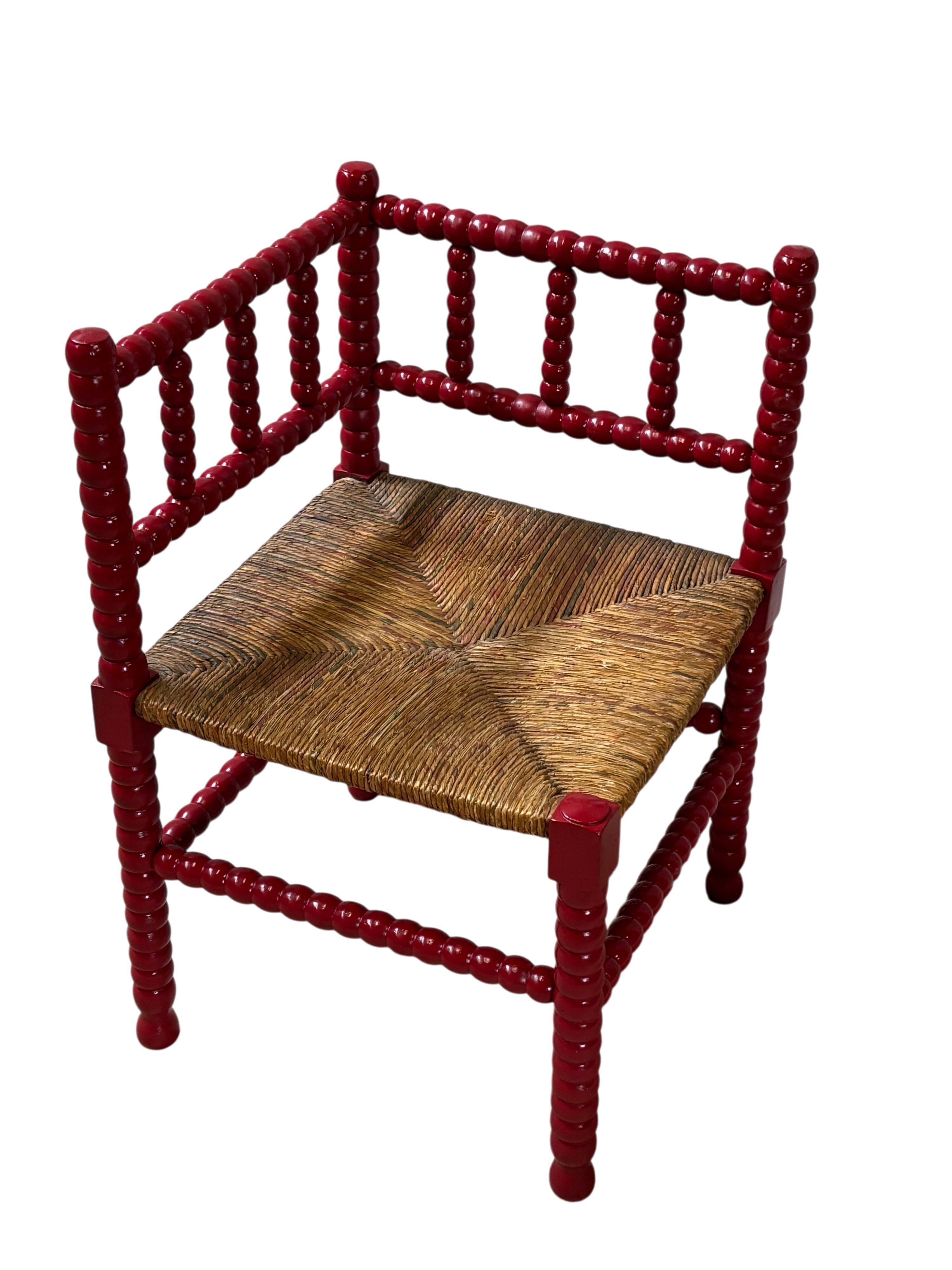 Red turned wood corner chair with rush seating