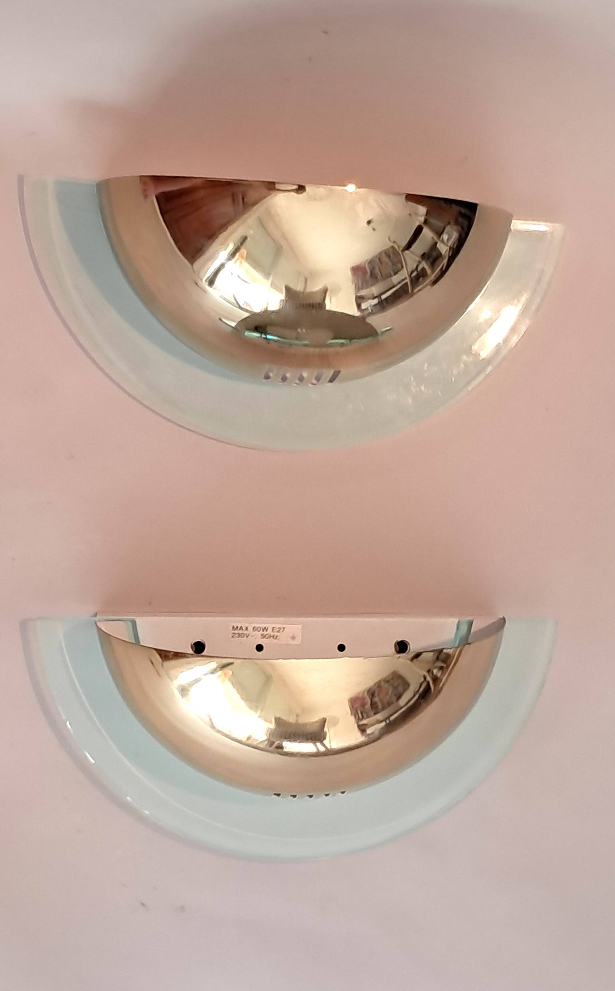 Pair of gold metal and plexiglass wall lights, circa 1980.