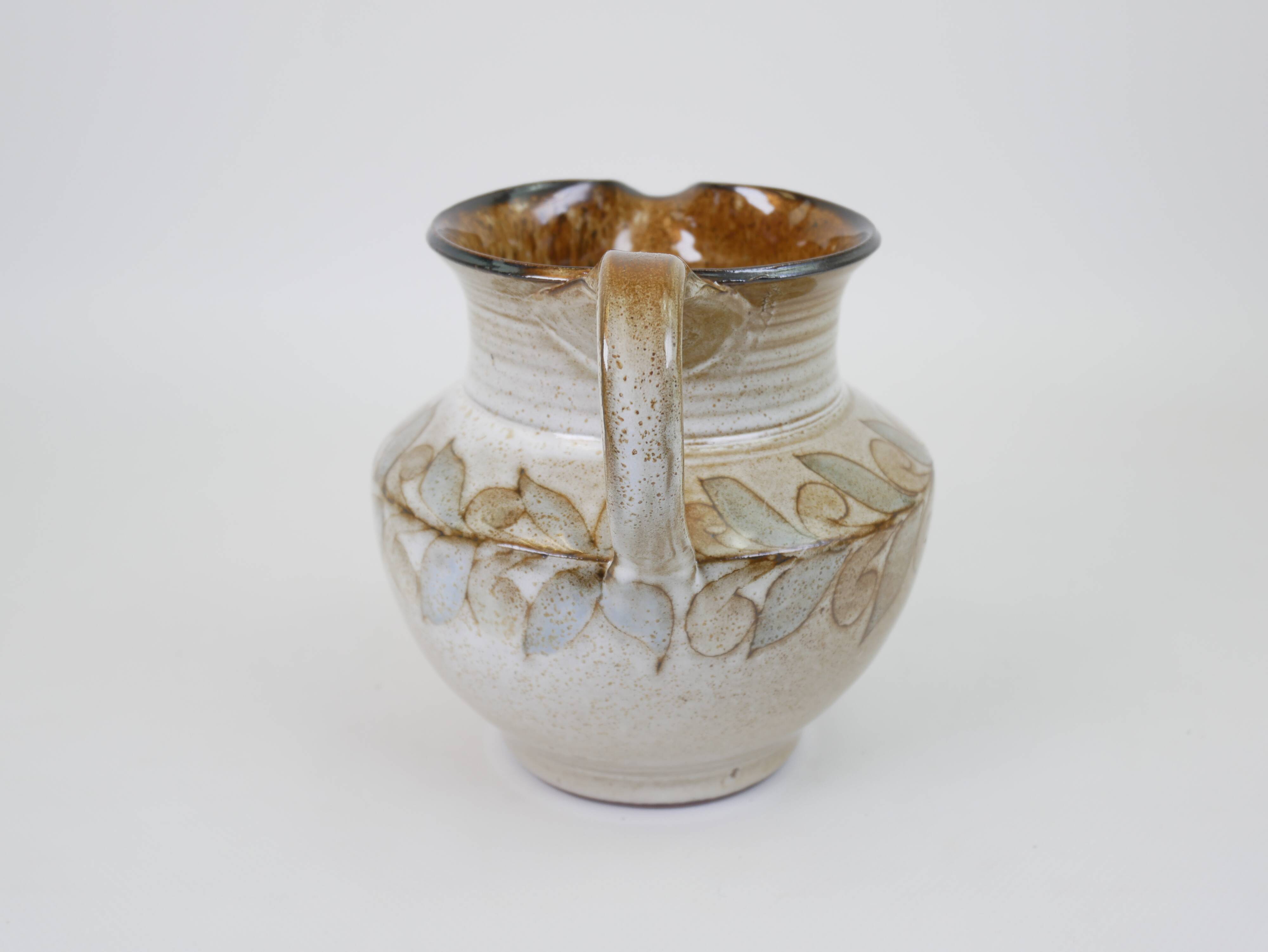Glazed ceramic jug with plant decoration