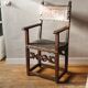 Antique armchair in walnut and studded leather, 17th century