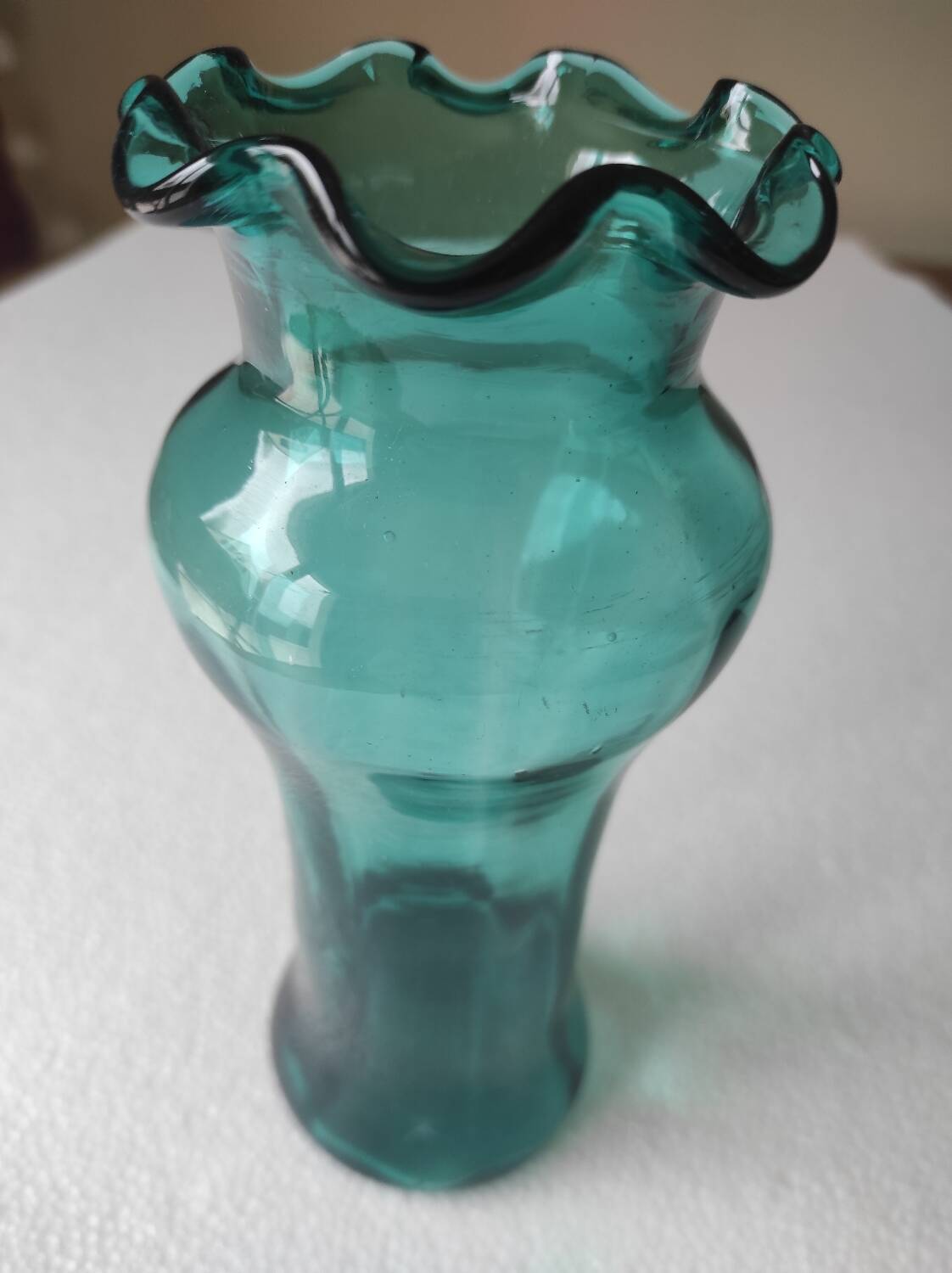 Blown glass vase with a flared neck and wavy rim.