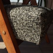 Vintage design armchair in mixed black fabric, walnut-coloured wood.