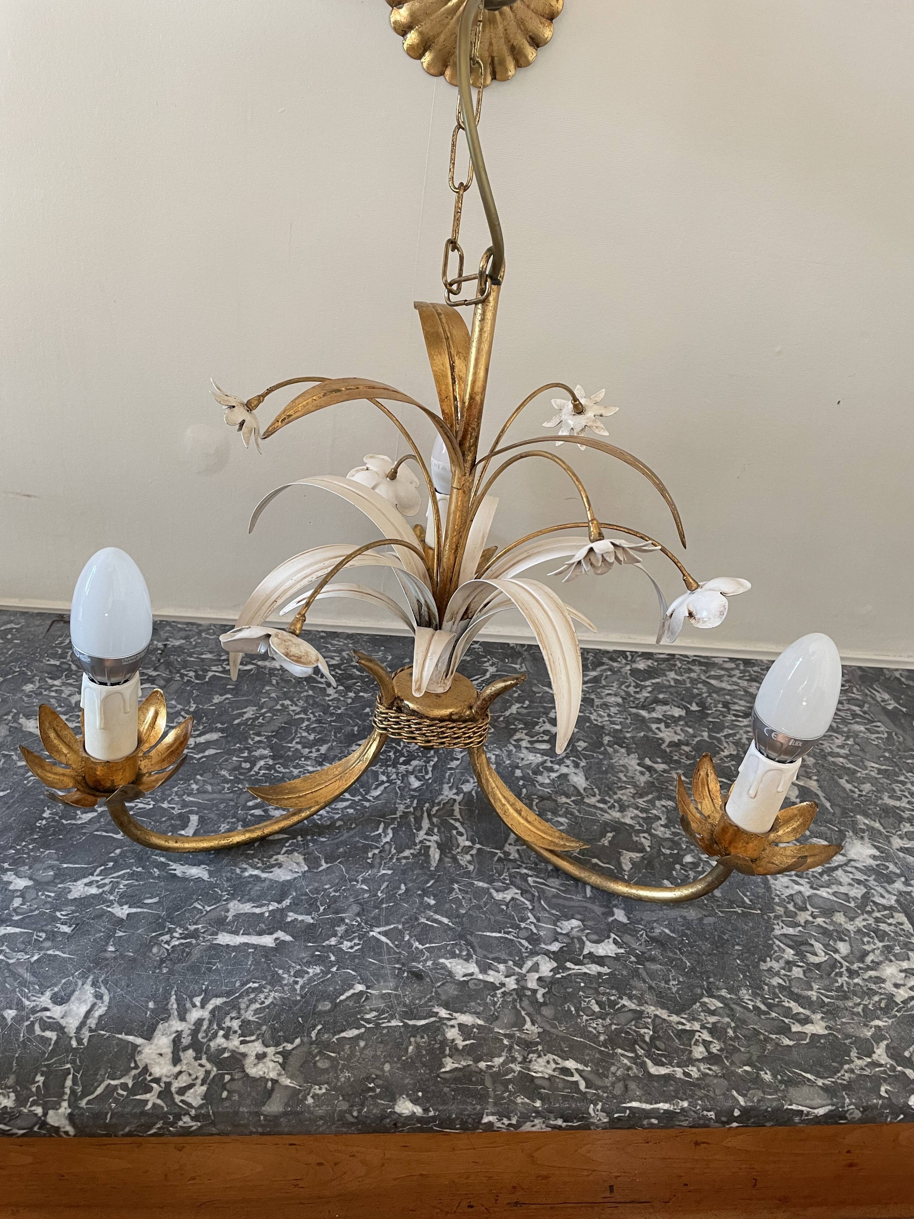 Golden metal chandelier decorated with flowers