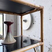 Rattan bookshelf and black glasses