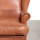 Light cognac-coloured cow leather wingback armchair with matching piping