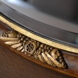 Old oval beveled wooden mirror, partly gilded and carved