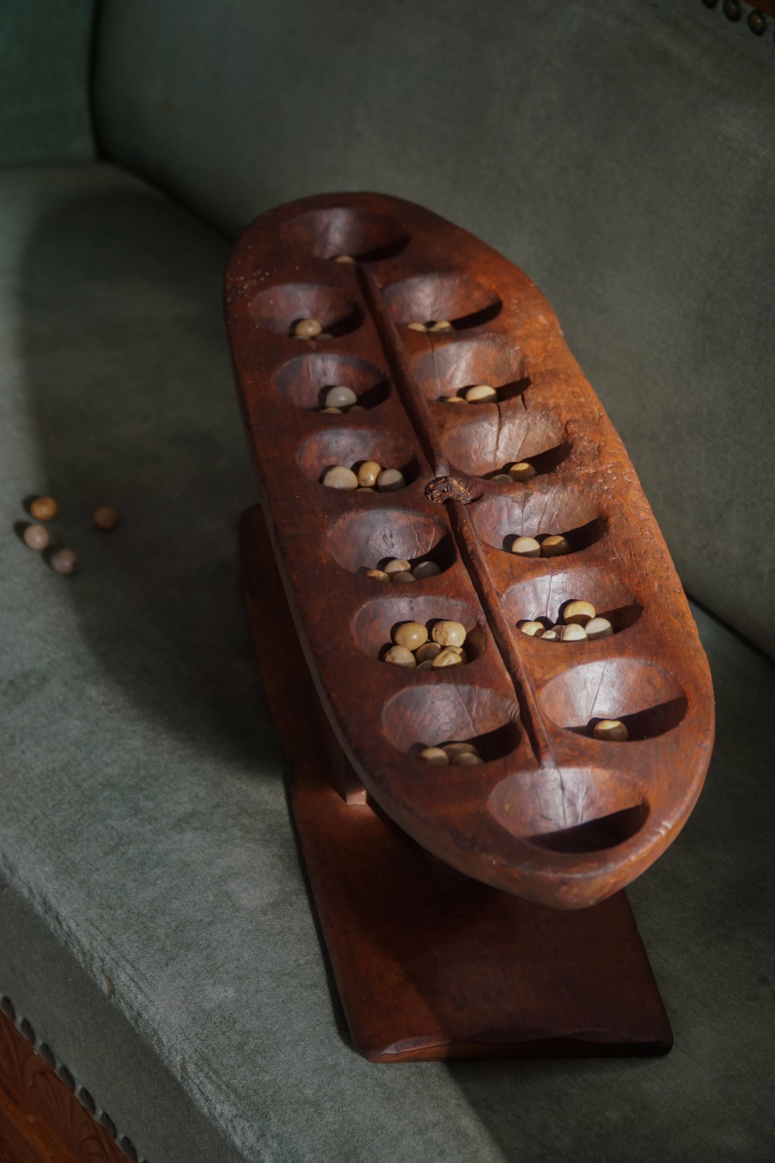 Decorative Mancala game board made of hand-carved wood, Africa, mid-20th century.
