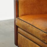 Sheepskin Art Deco design armchair with beautiful wooden details and black piping