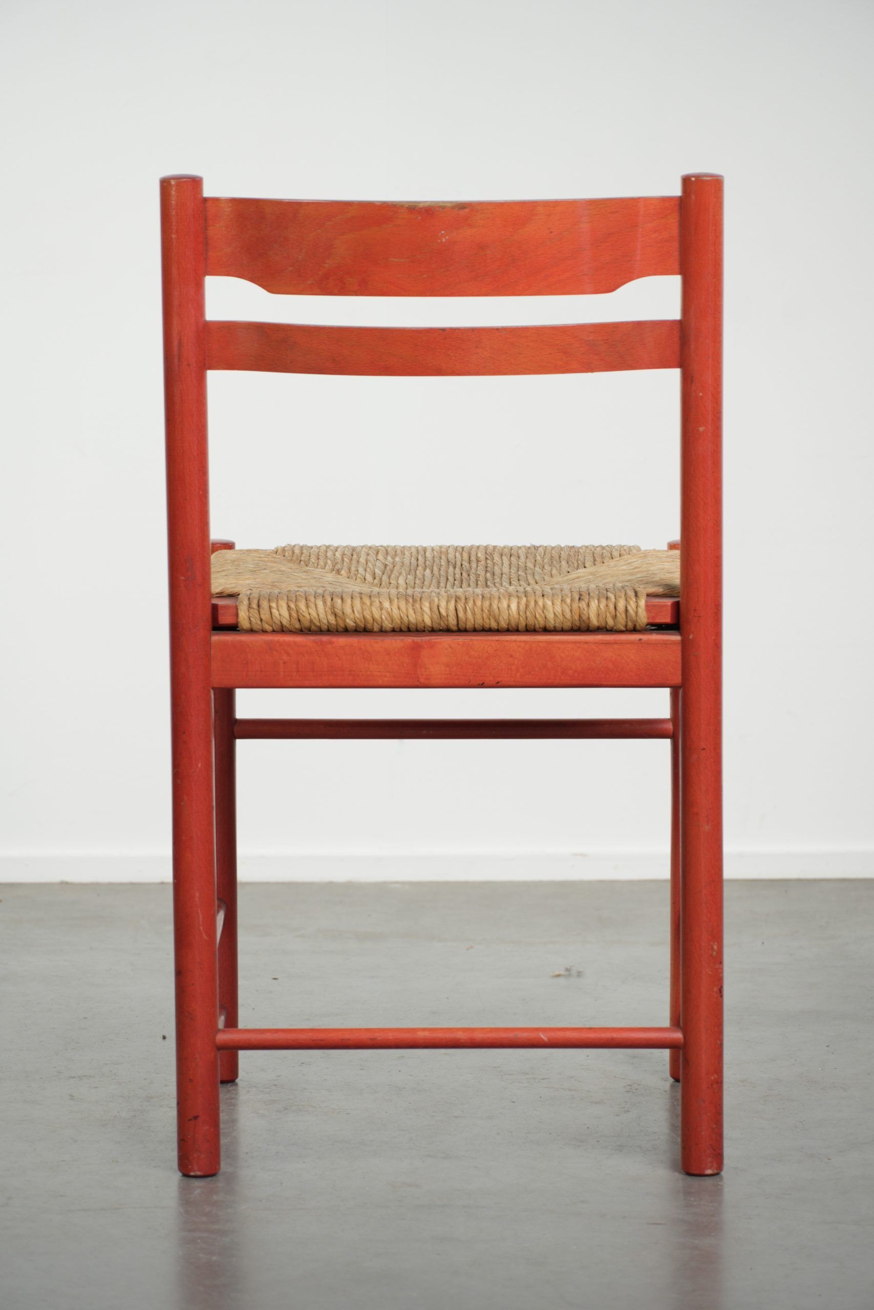 Nice red vintage wooden chair from the 1970s with a woven wicker seat